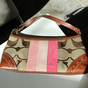 Cute Coach bag. One side has pink stripes. Pink interior. Good condition.